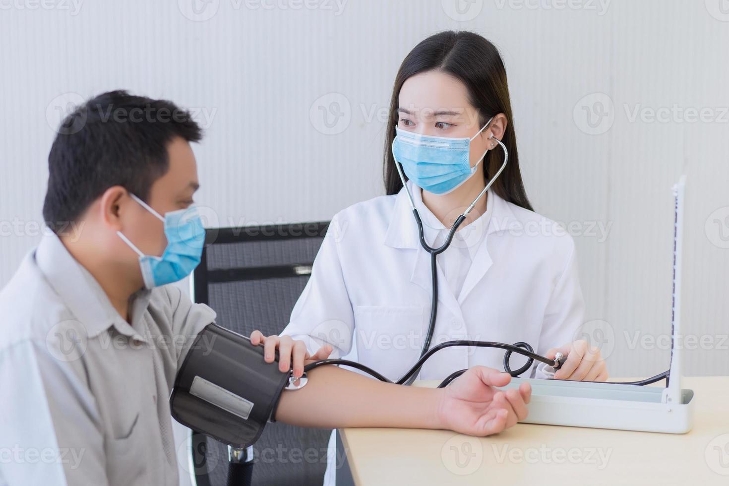 la doctora asiática usa estetoscopio y un motor de presión arterial para medir la presión arterial del paciente hombre. en el concepto de salud, foto