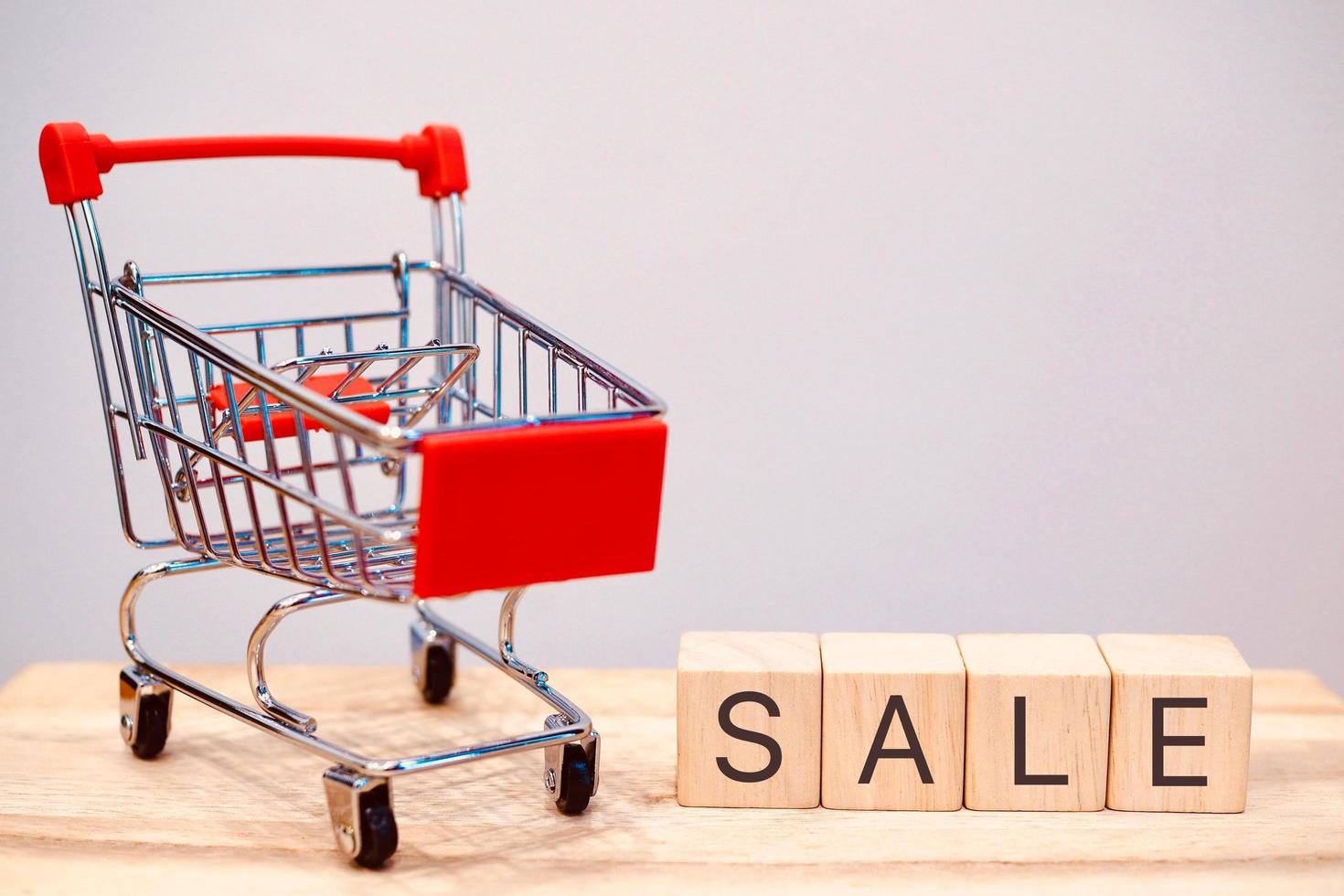 A shopping cart on wheels with a red label about discounts in a store or supermarket. photo