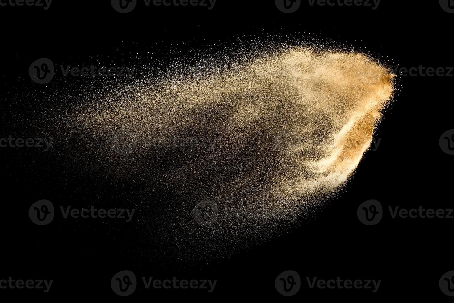 Brown colored sand splash against dark background. Dry river sand explosion isolated on black background. Abstract sand cloud. photo