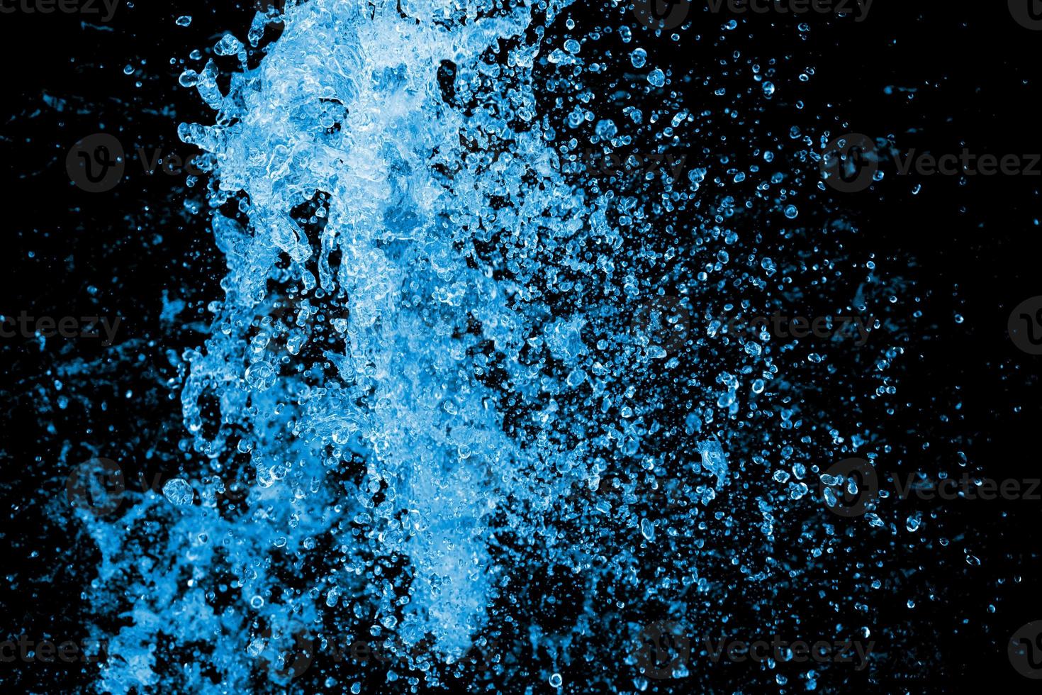 salpicaduras de agua azul sobre el fondo negro. cierre el chorro de agua del uso de la manguera para el fondo abstracto. foto