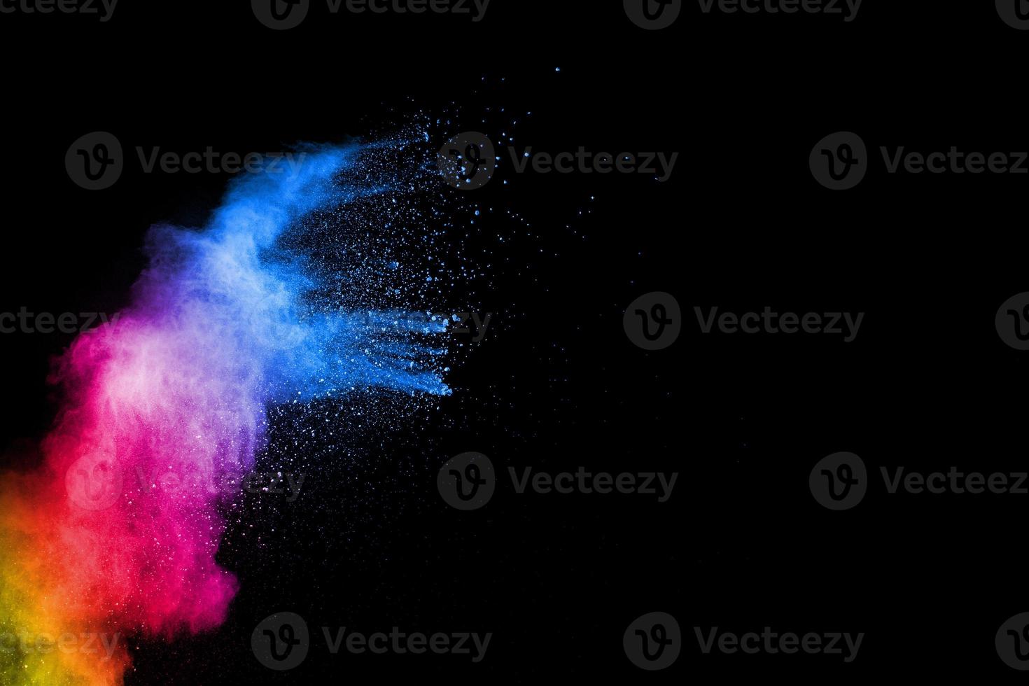 explosión de polvo colorido abstracto sobre fondo negro. movimiento de congelación de salpicaduras de polvo. holi pintado. foto