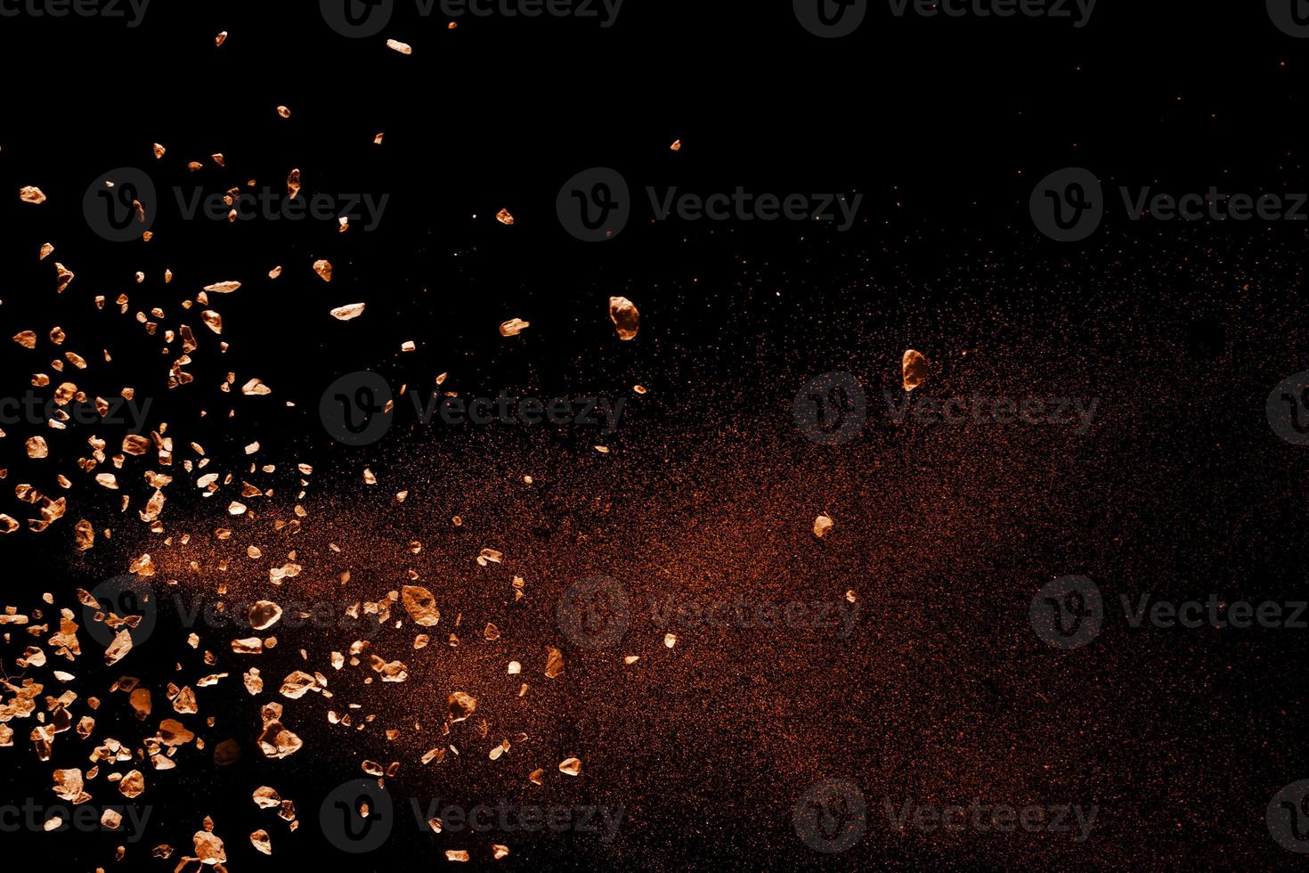Split debris of stone exploding against black background. photo
