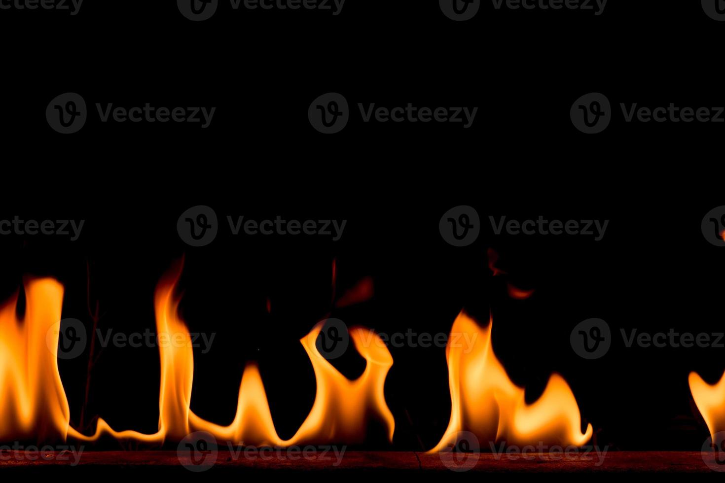 llamas de fuego de la naturaleza sobre fondo negro. congelar el movimiento de las llamas de fuego rojo-amarillo que arden en la noche oscura. foto