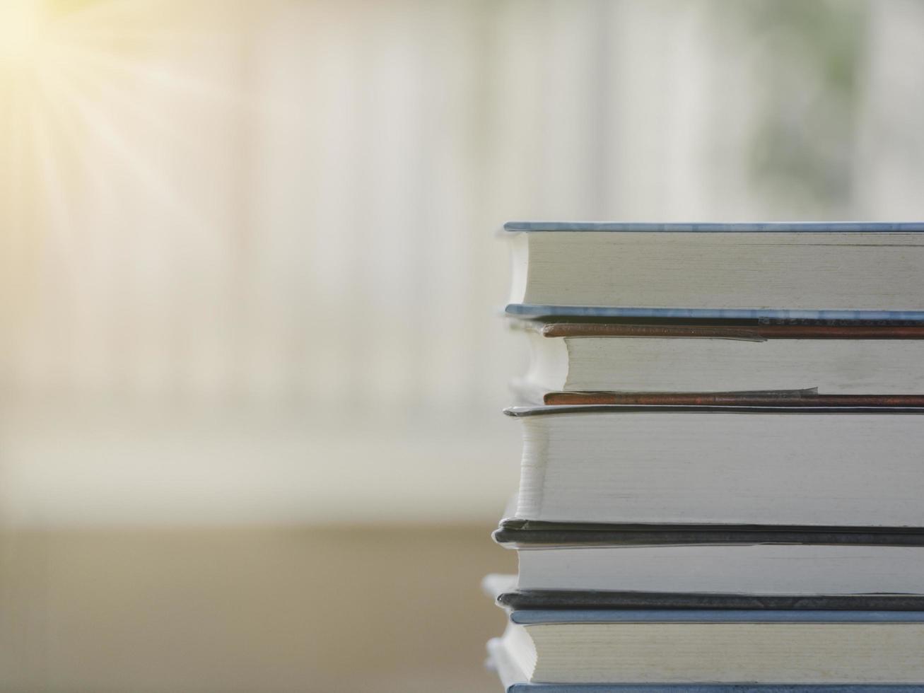 A simple composition of many books, stack or pile of books on wooden table, one of them open with copy space. photo