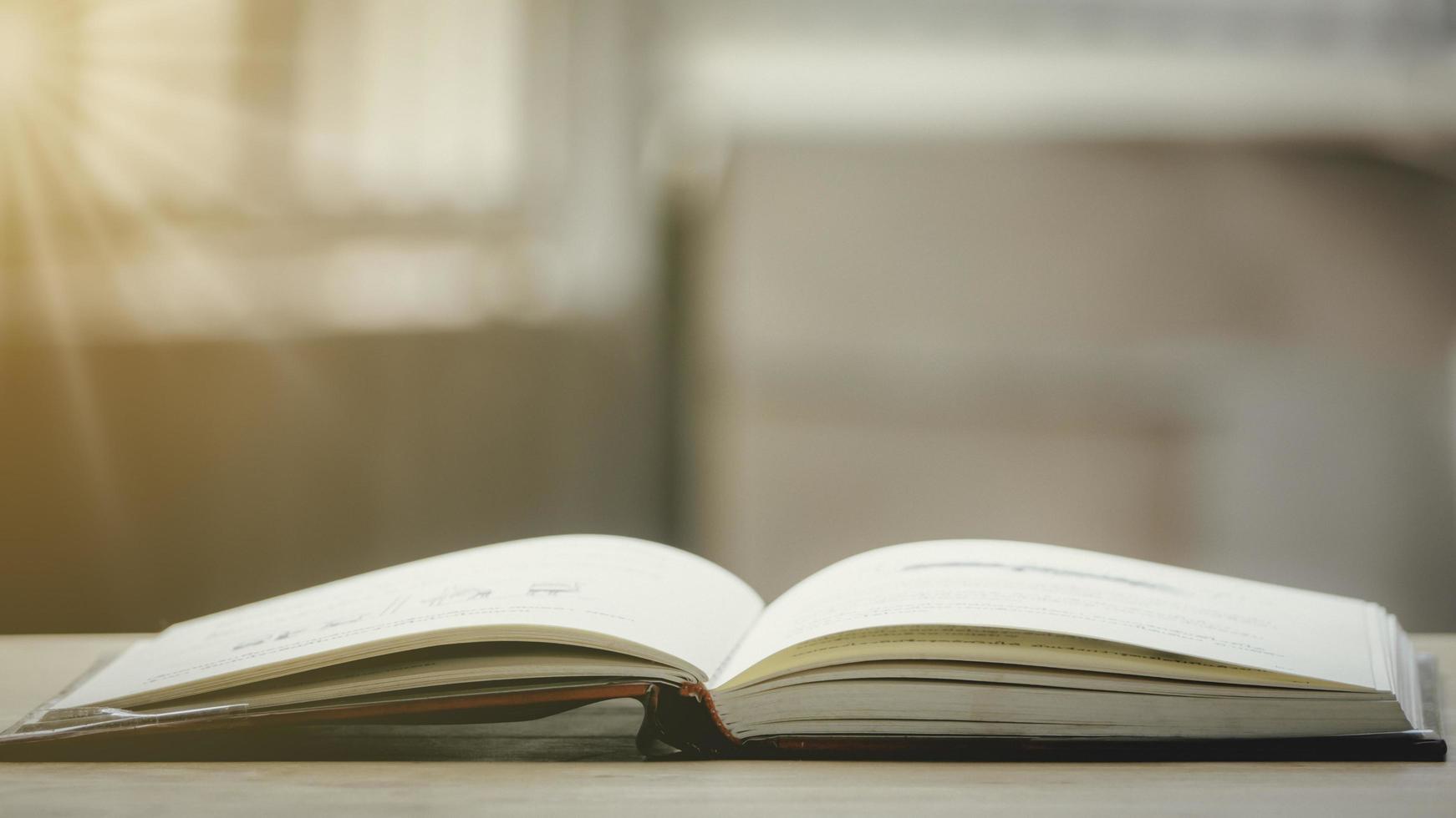 A simple composition of many books, stack or pile of books on wooden table, one of them open with copy space. photo