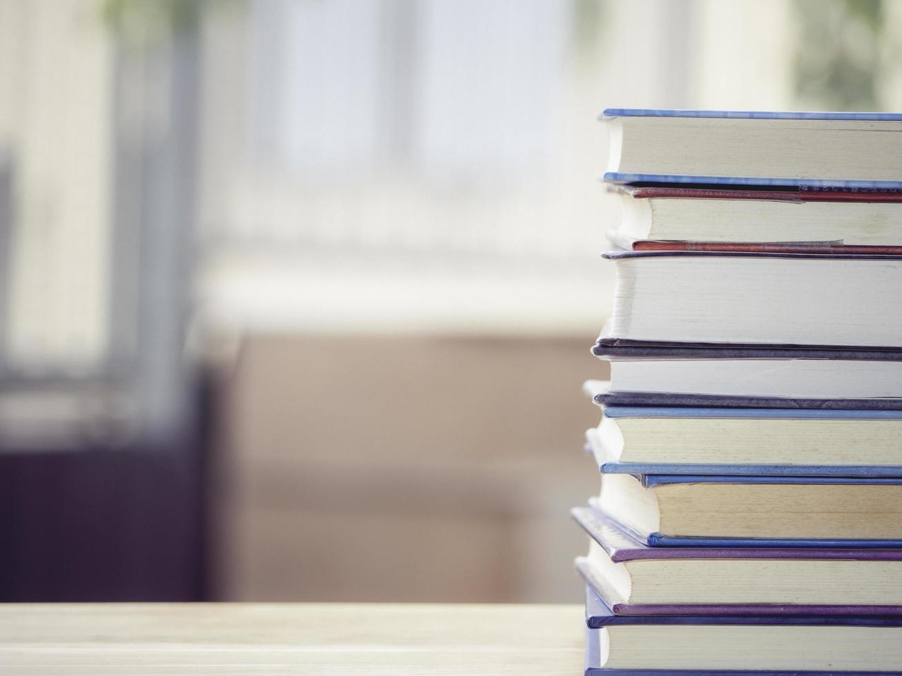 A simple composition of many books, stack or pile of books on wooden table, one of them open with copy space. photo