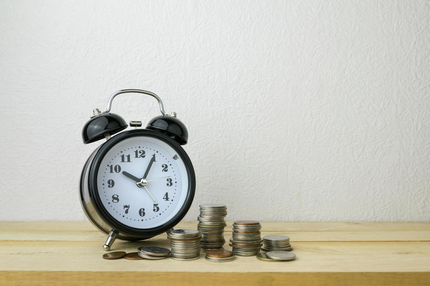 clock and stacks of coins for business money concept photo