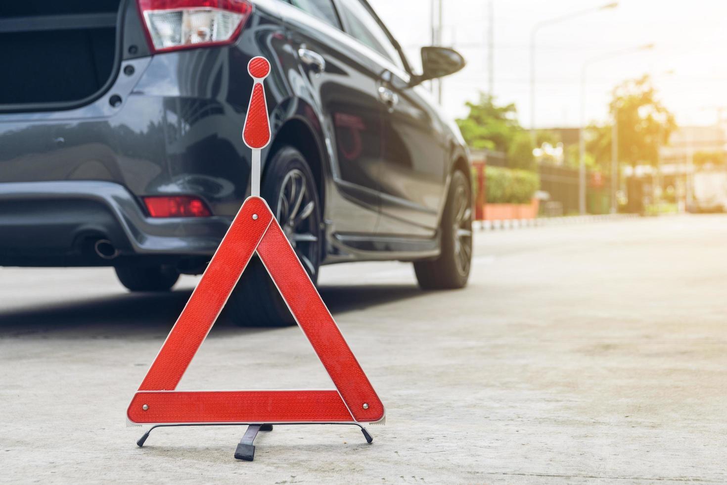 Broken car sign on a road with a broken down car photo