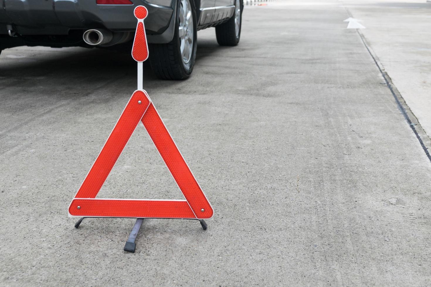 Broken car sign on a road with a broken down car photo