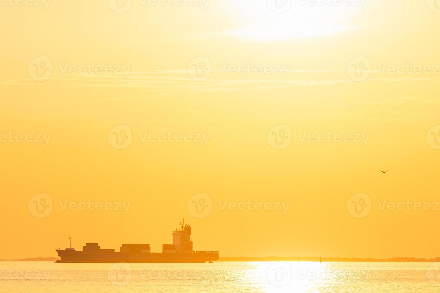 Container cargo ship in the ocean at sunset sky background at Bangpoo, Samutprakarn, Thailand. photo