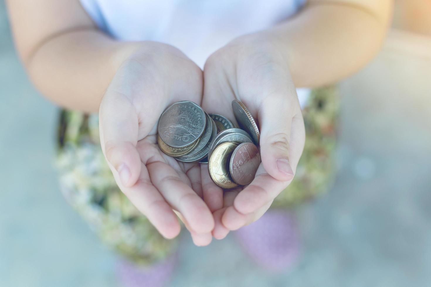 moneda en la mano de los niños. concepto de negocios y finanzas foto