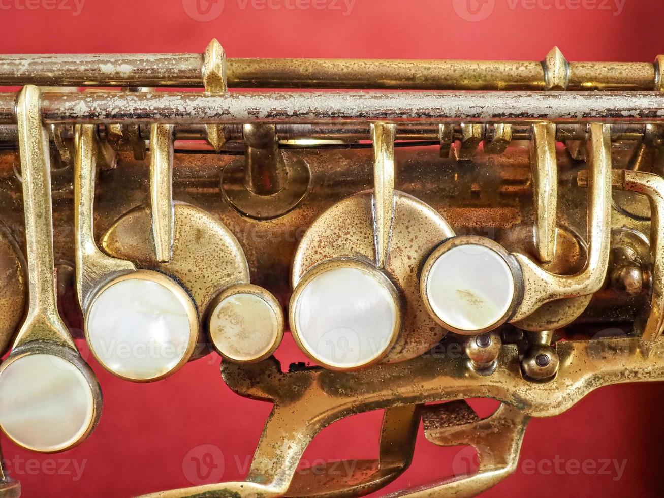 un saxofón de latón contra un fondo rojo foto