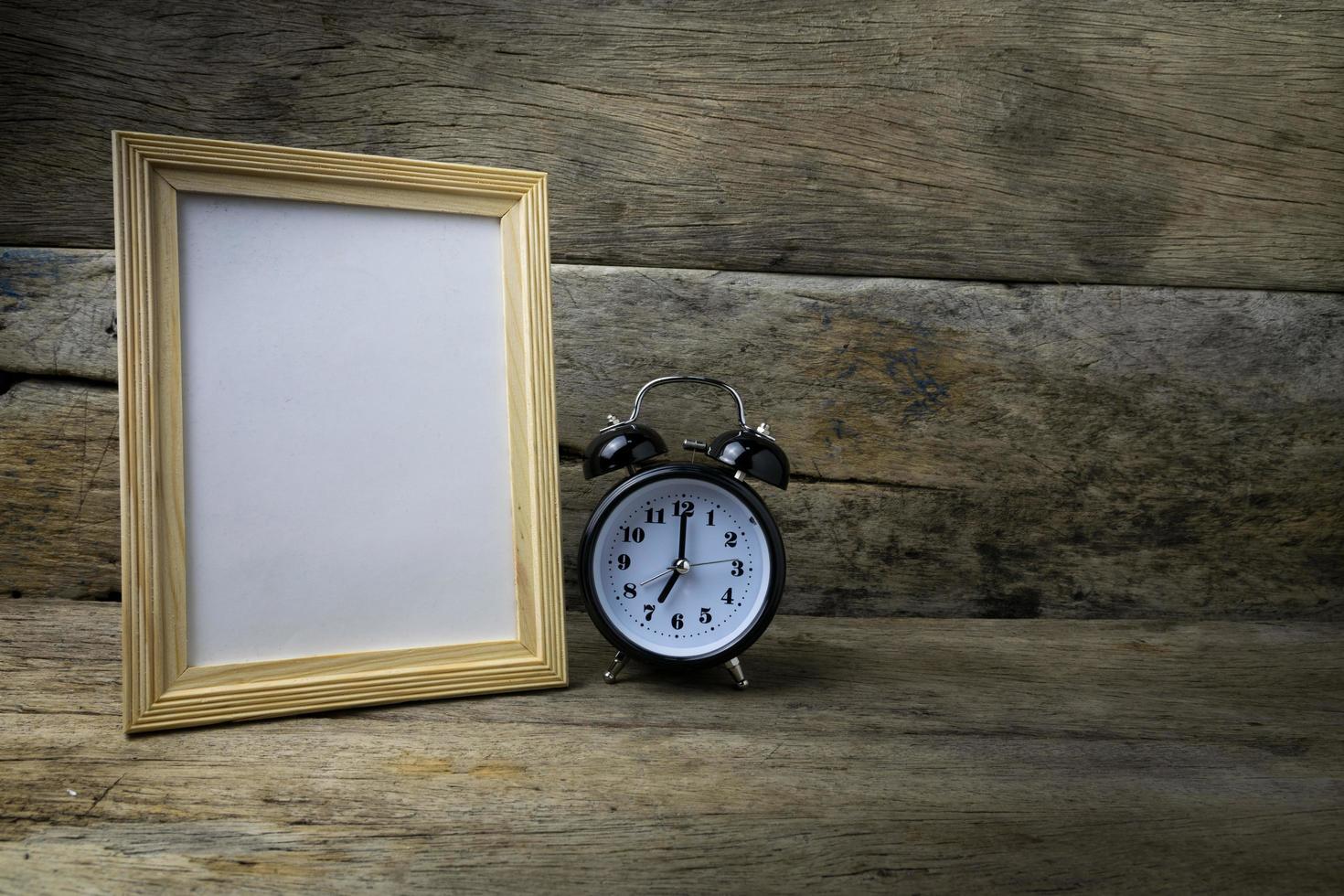 Wood photo frame and clock on wooden table