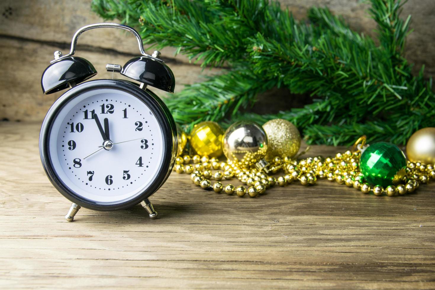 Alalrm-clock and Christmas baubles on wooden background photo