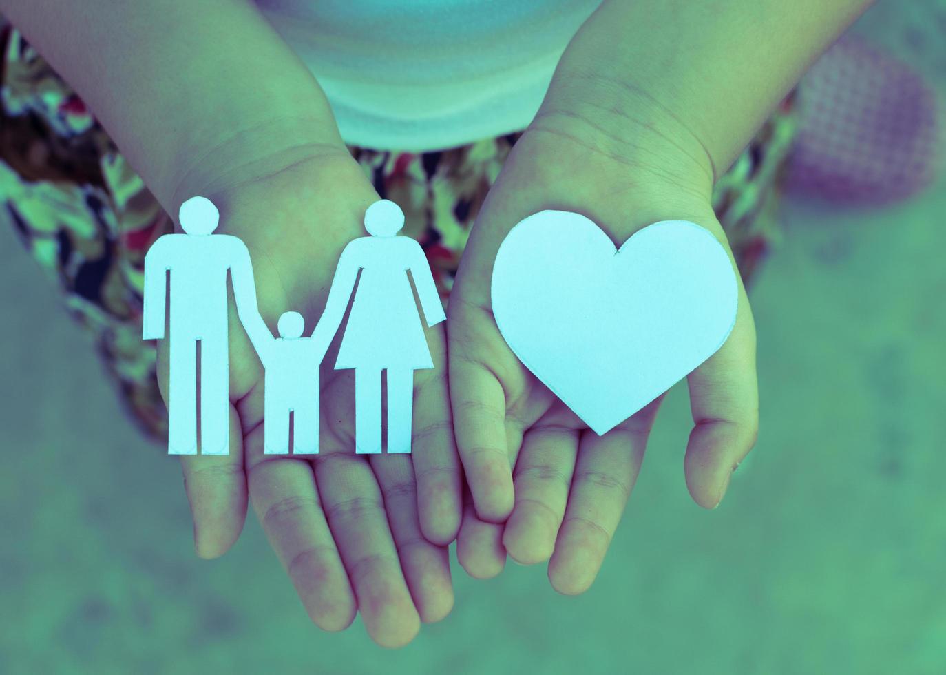 Children hands holding small model of heart and family , concept family photo