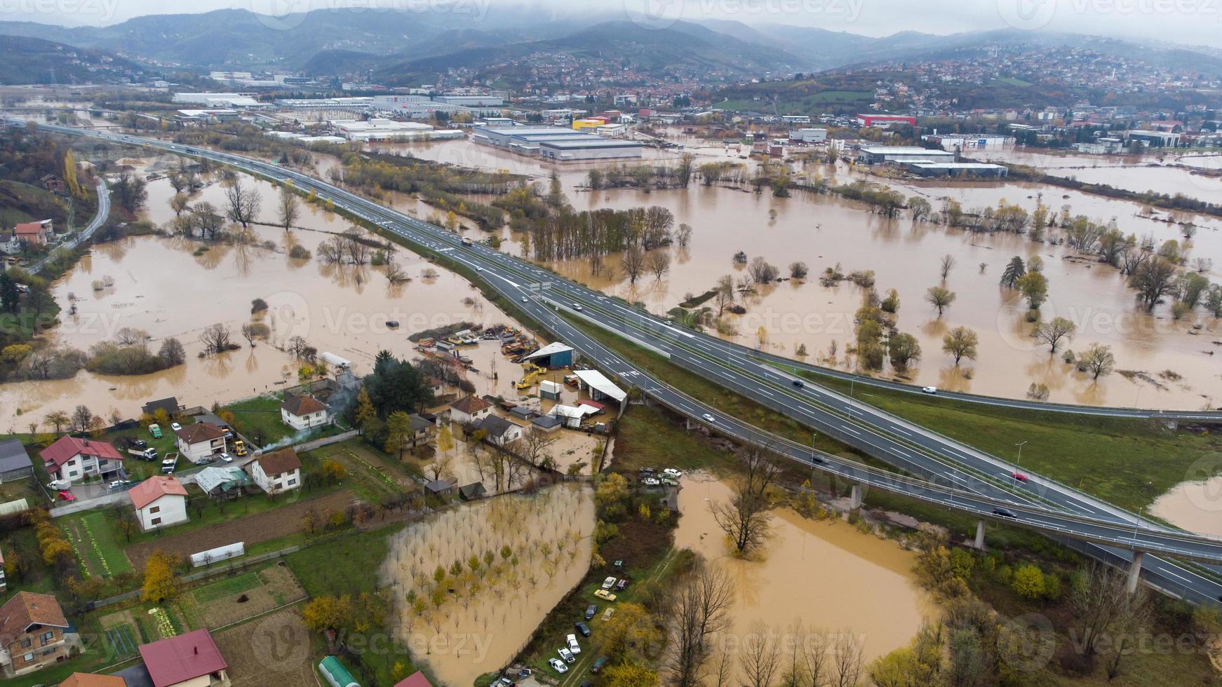 la vista aérea de drones de la lluvia torrencial provoca inundaciones repentinas en áreas residenciales. casas y caminos rodeados de agua. cambio climático. consecuencias de las fuertes lluvias. foto