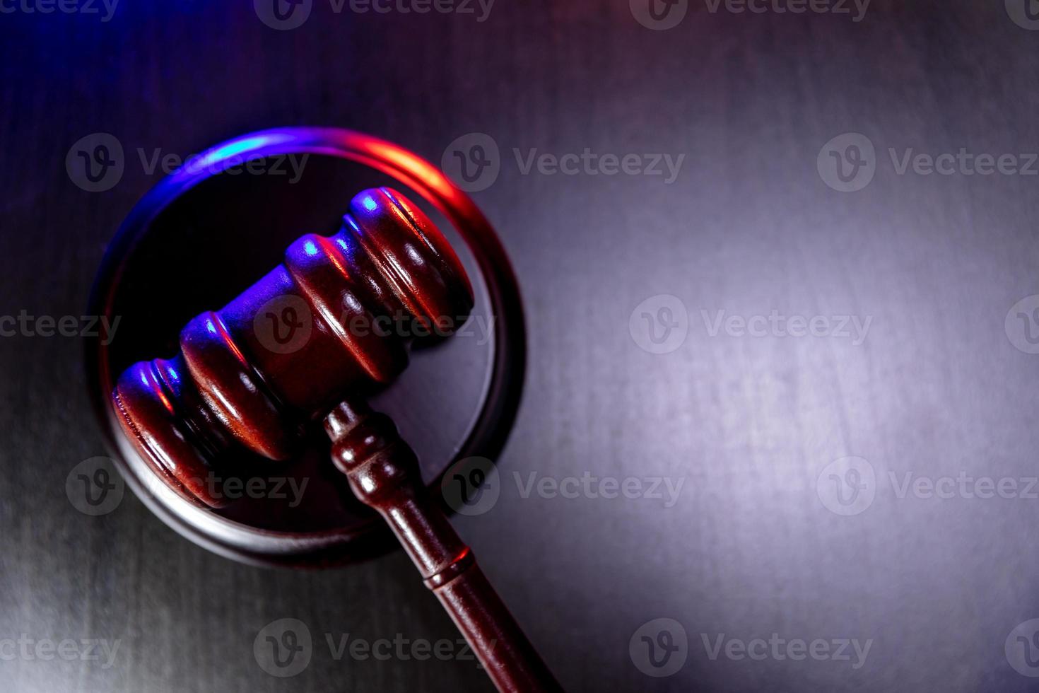 Law theme. Court of law trial in session. Judge gavel on wooden table with police emergency services light. Mallet of judge on dark background. Justice human rights concept. Copy space. photo