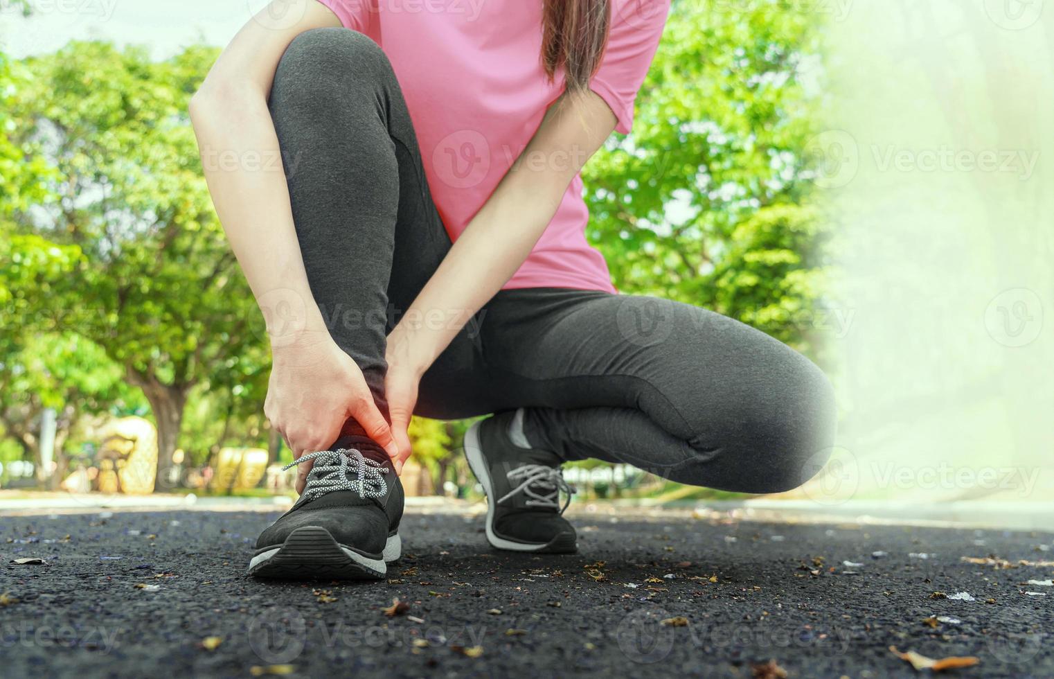 Young woman has pain in his foot while running in the park. photo