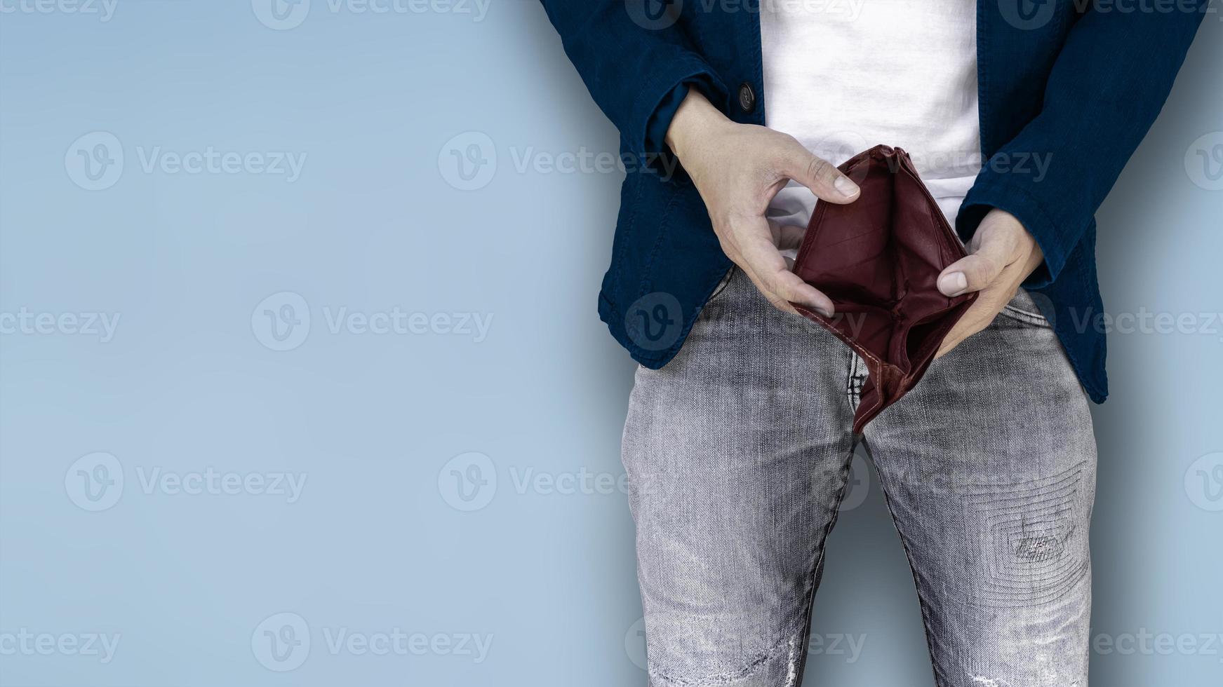 Young employee showing an empty wallet in the his hands. photo
