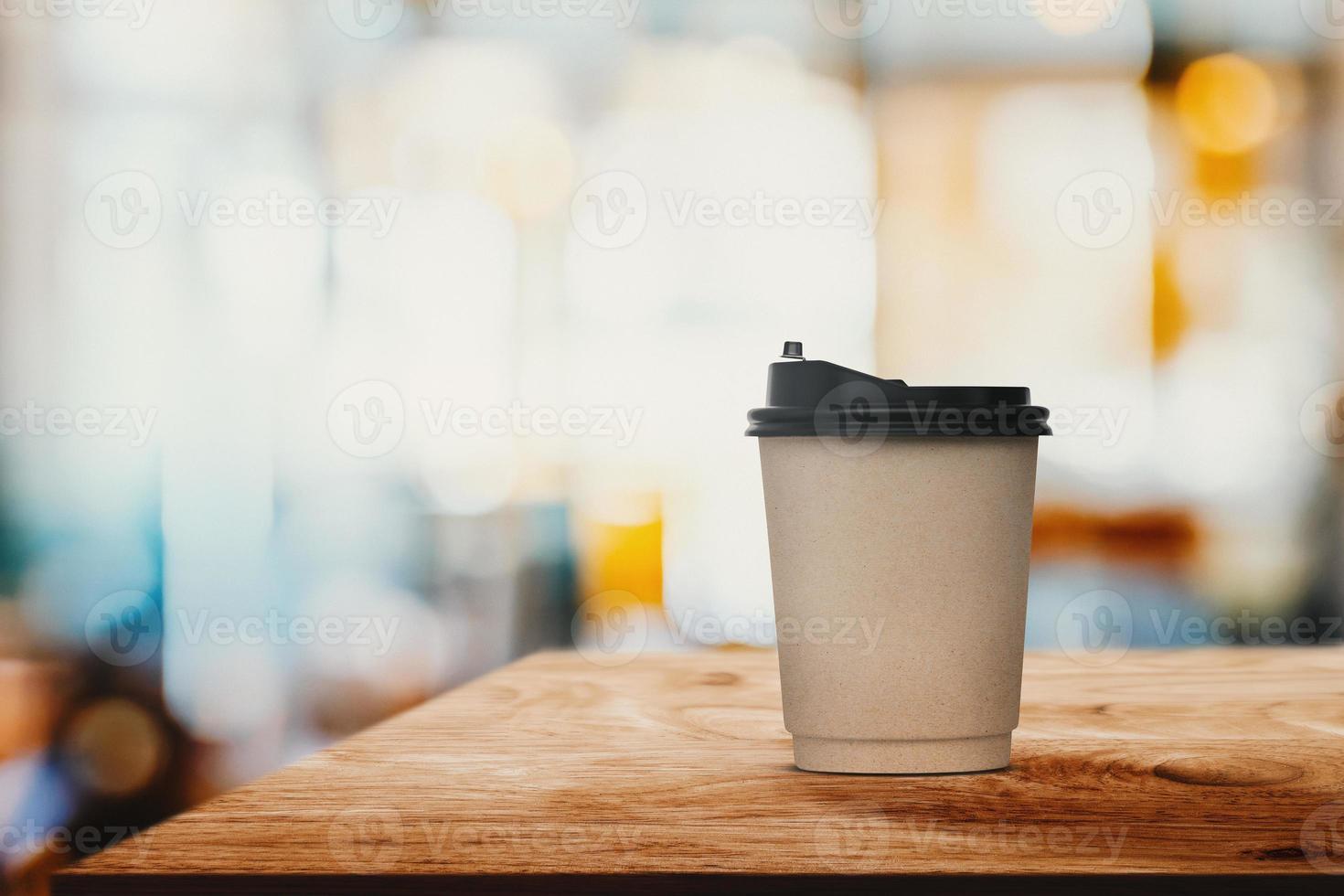 Paper coffee cup on wood table with abstract blur interior coffee shop or cafe for background. photo