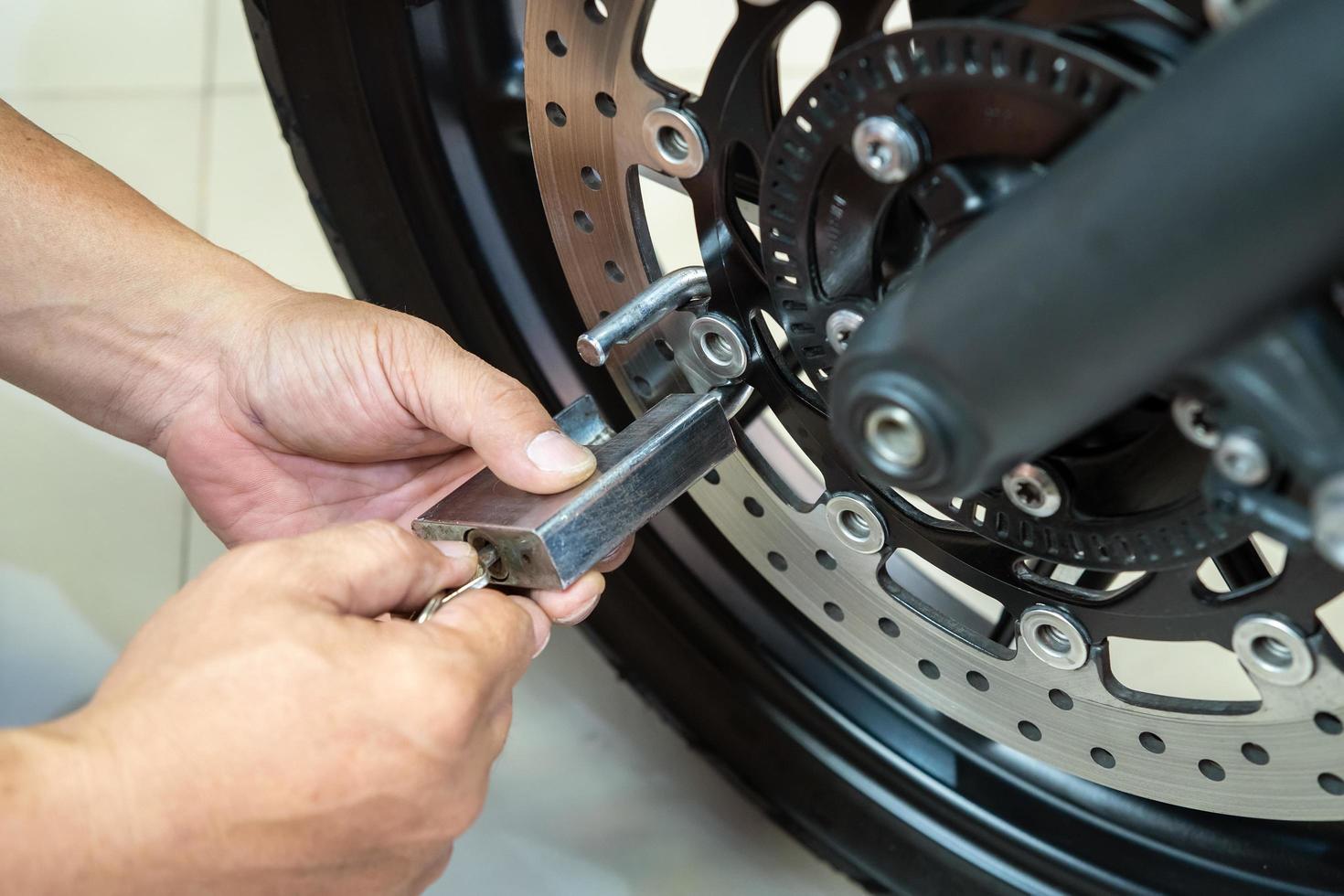 Motorcycle owner use  padlock and Lock on Motorbike Disc Brake ,Motorcycle Security and Anti-Theft concept photo