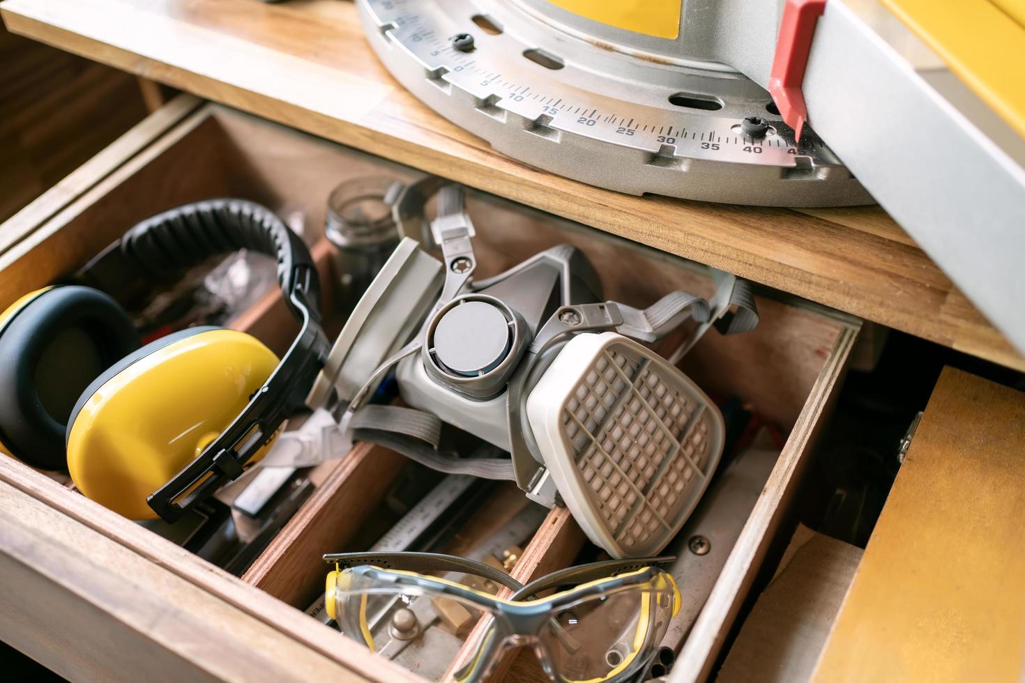 safety equipment in drawer ,Respirator Cartridge Filter , glasses, ear muffs at carpentry work room ,Work safety concept photo