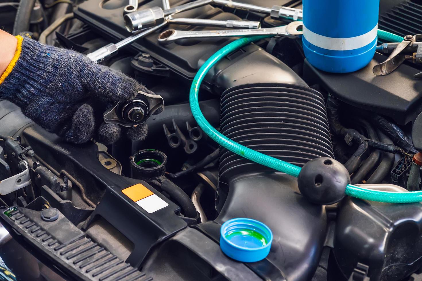 hand of Mechanic check water in car radiator and add water antIfreeze