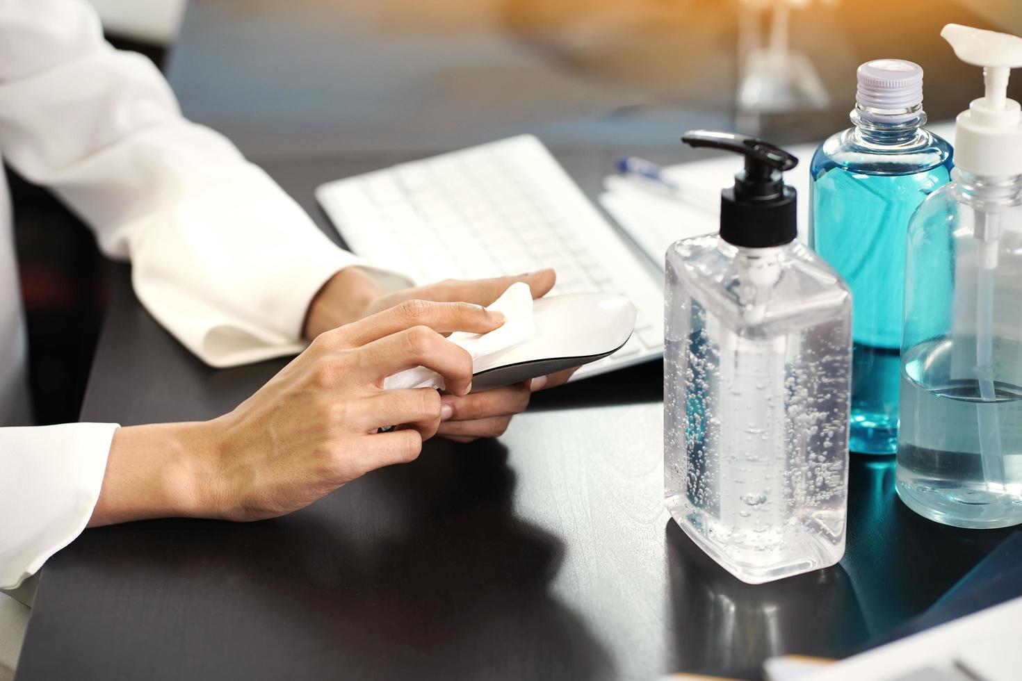 Women Cleaning a computer mouse with alcohol pad. Hygiene sanitize concept. prevent the spread of germs and bacteria and avoid infections corona virus or covid 19.selective focus photo