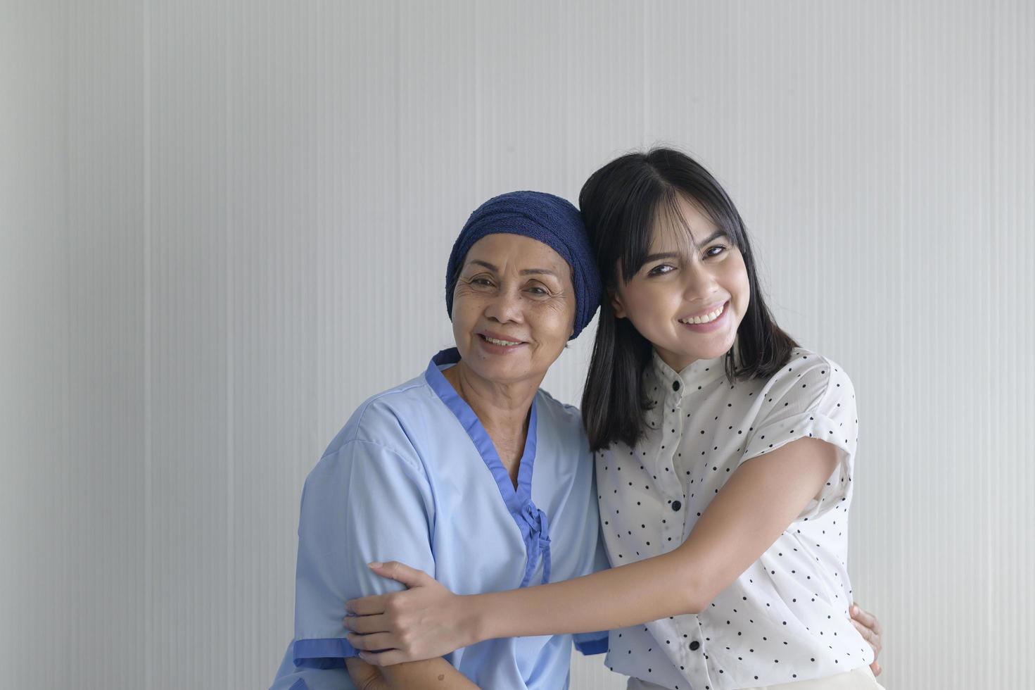 Cancer patient woman wearing head scarf and her supportive daughter in hospital, health and insurance concept. photo