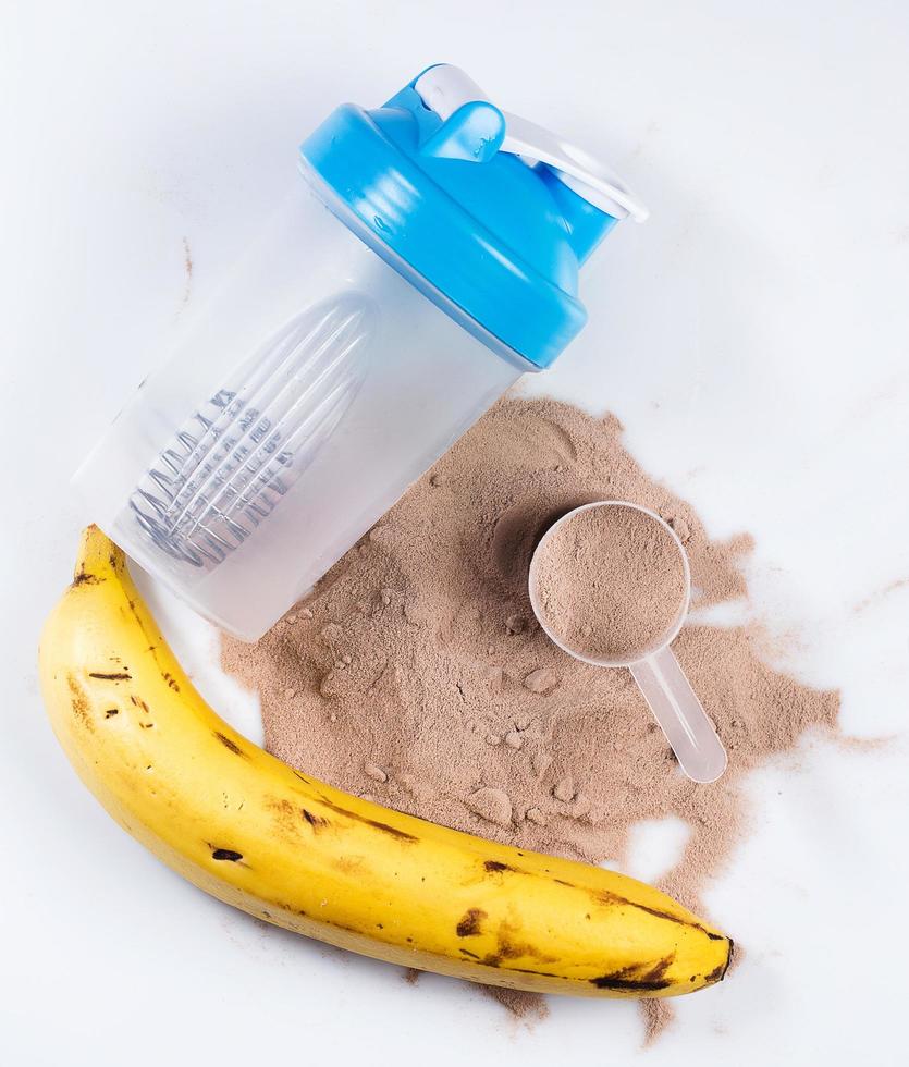 Shaker, protein powder and banana photo