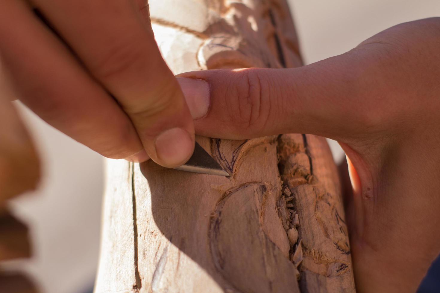 Cerrar imagen de tallador de madera en el trabajo, artesanía con madera foto