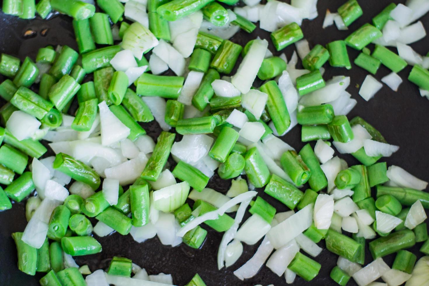Coocking of green beans and garlic, fresh vegatables on wooden table photo