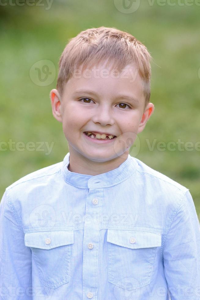 A boy of primary school age runs with balloons. The boy celebrates his birthday in the park. photo