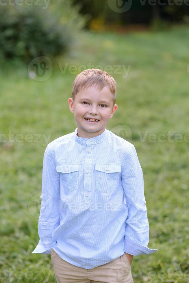 A boy of primary school age runs with balloons. The boy celebrates his birthday in the park. photo