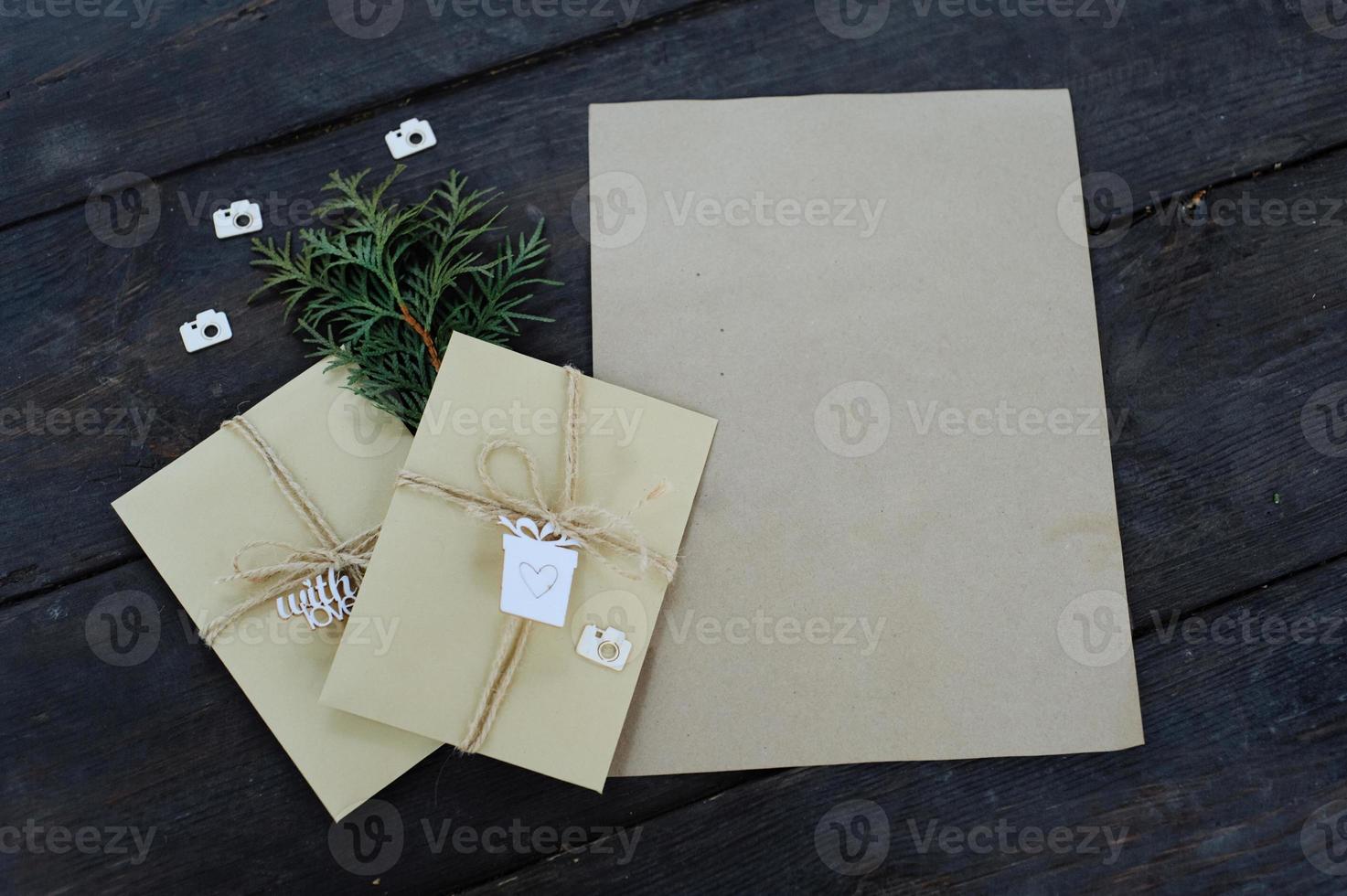 Brown kraft envelopes tied with an old tourniquet on old wood background with copy space. Handmade gift wrap. photo