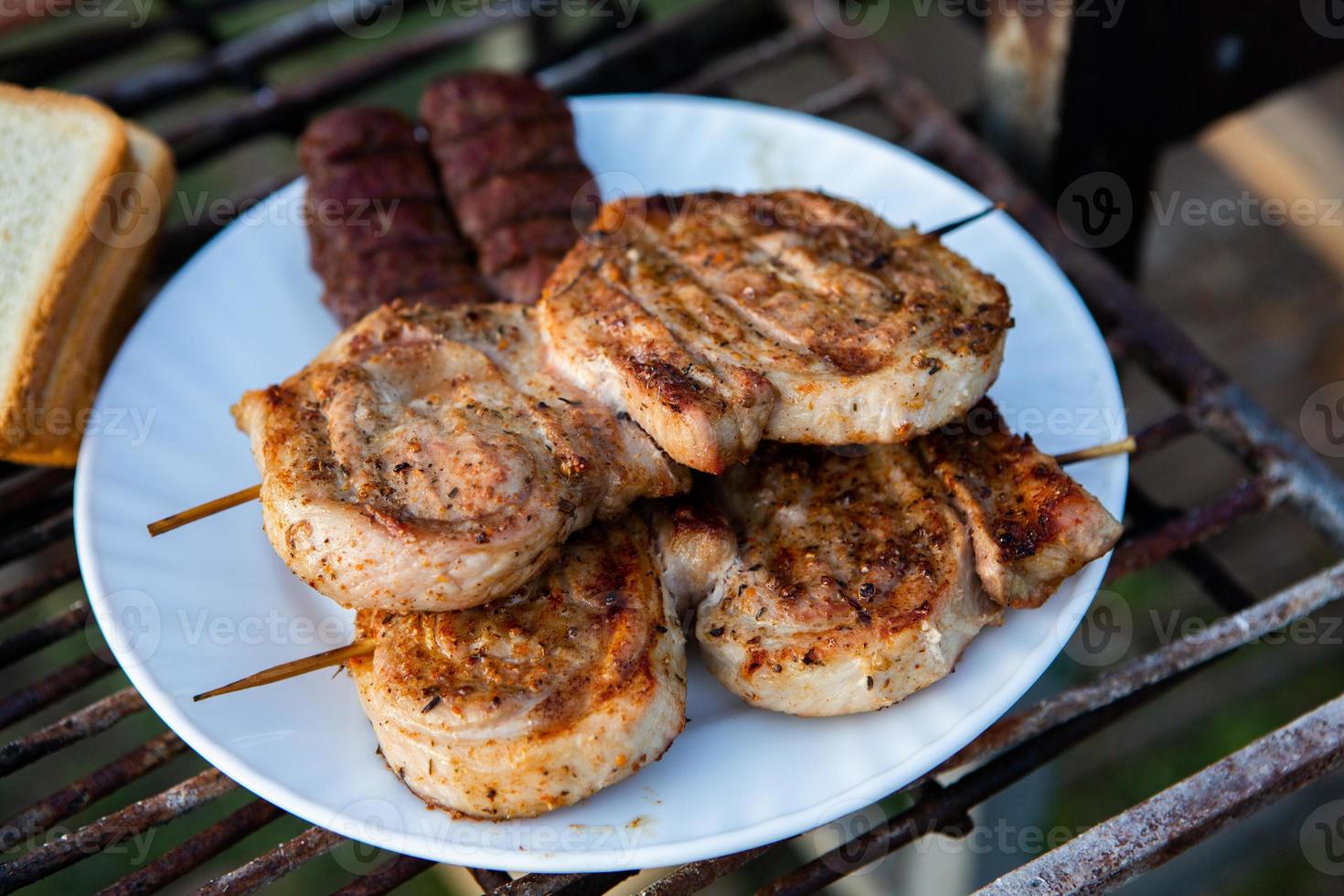 A large variety of grilled meat on the fire outside photo