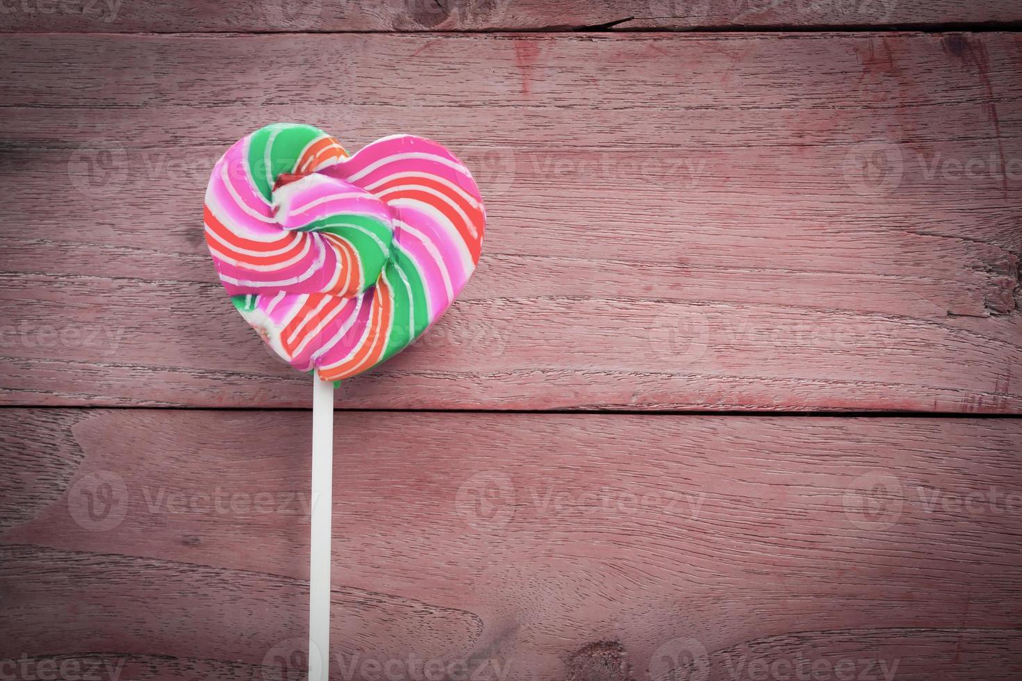 colorful heart lollipop on wood background photo