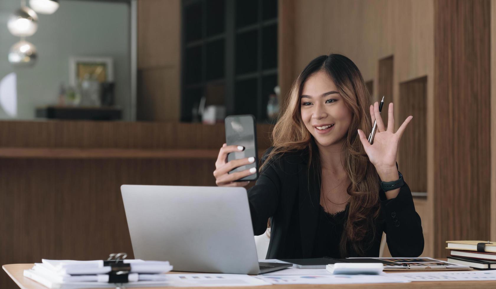 Video presentations conference young Asian businesswoman presenting presentations using video call at office. photo