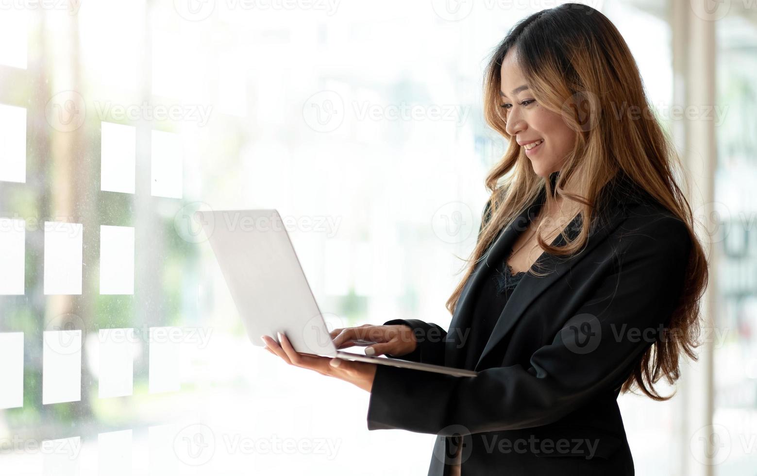 joven mujer de negocios asiática que trabaja en línea en una computadora portátil en la oficina. foto