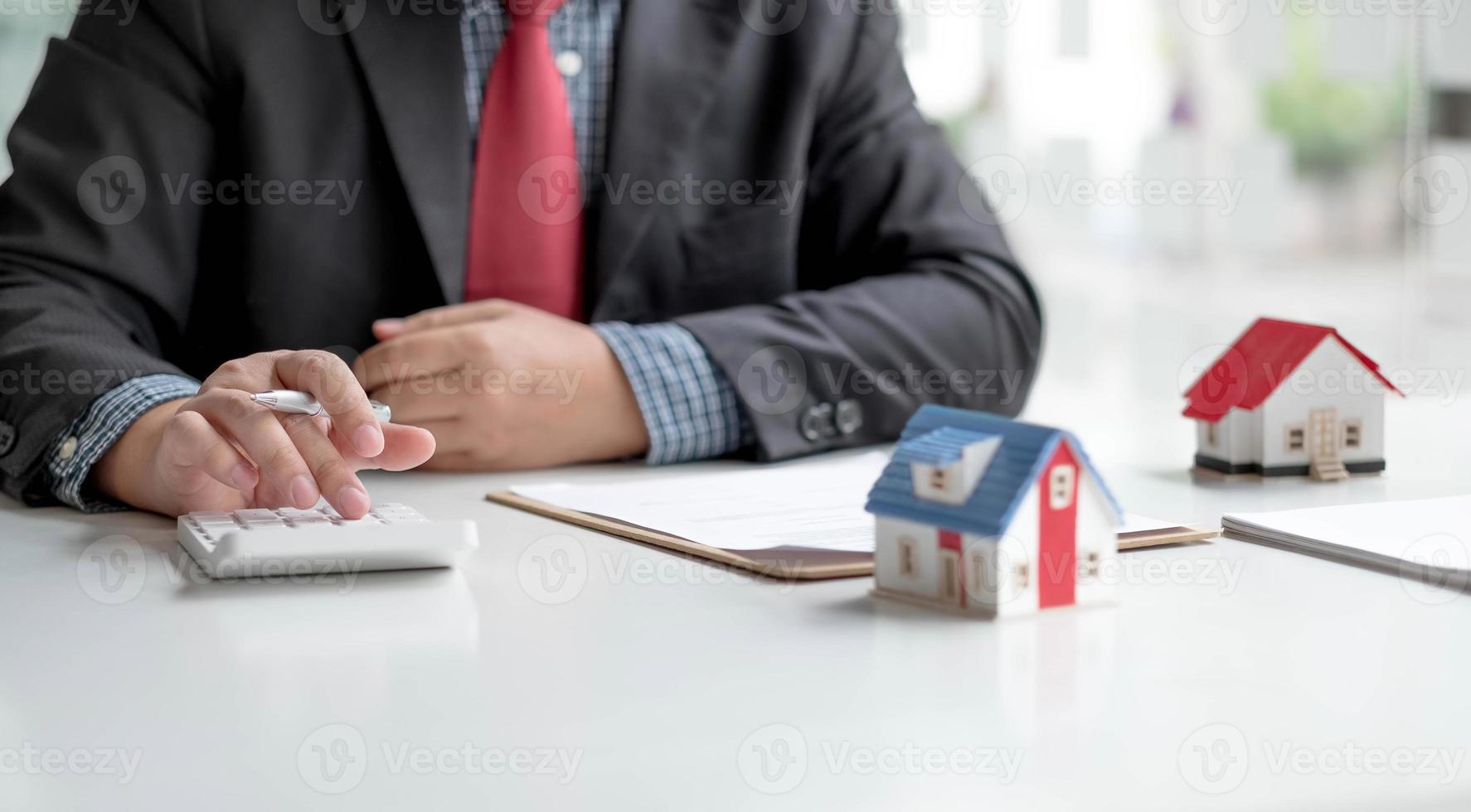 Businessman working doing finances and calculation cost of real estate investment while be signing to contract, Concept mortgage loan approval photo