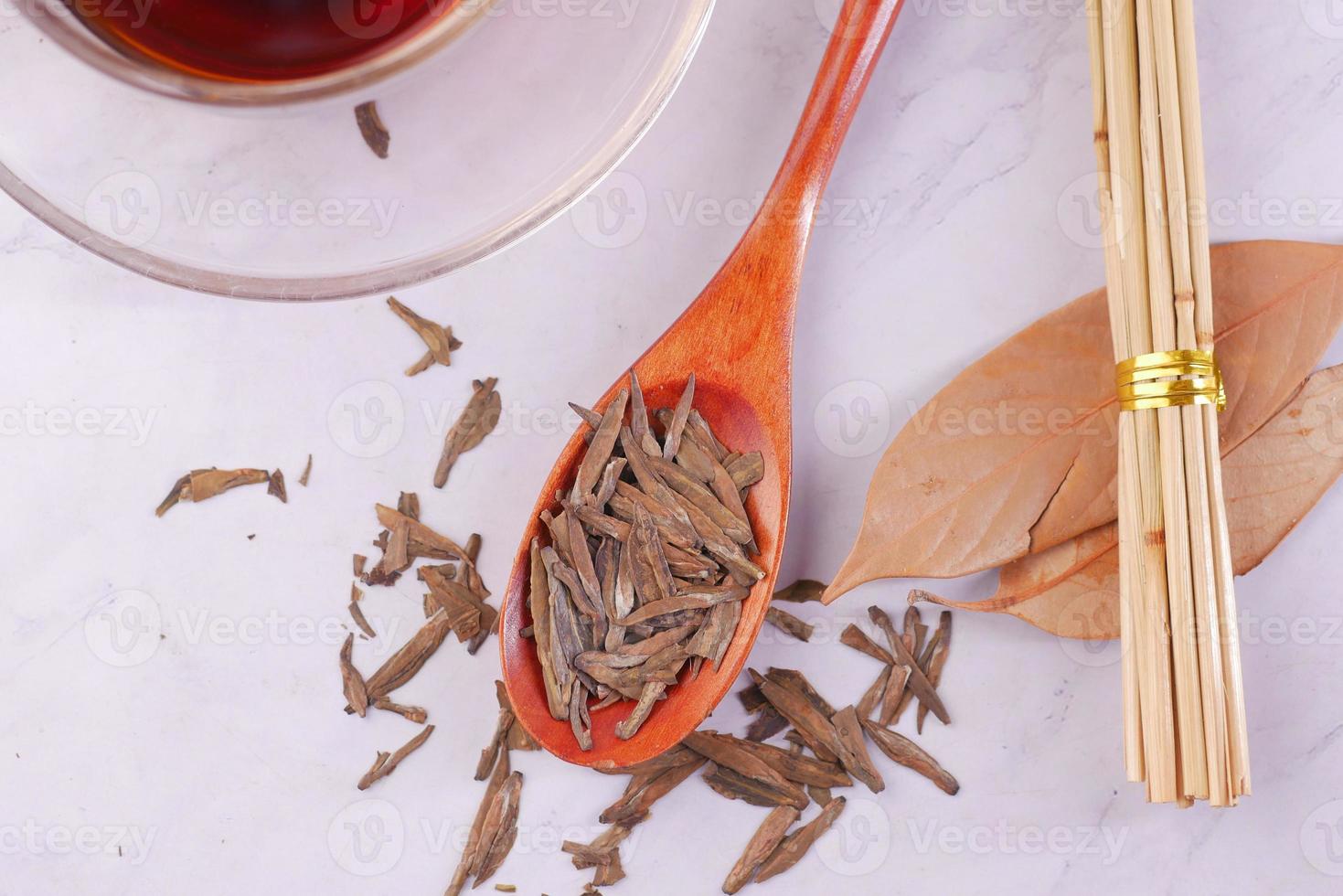 hojas de té secas en una cuchara de cerca. foto