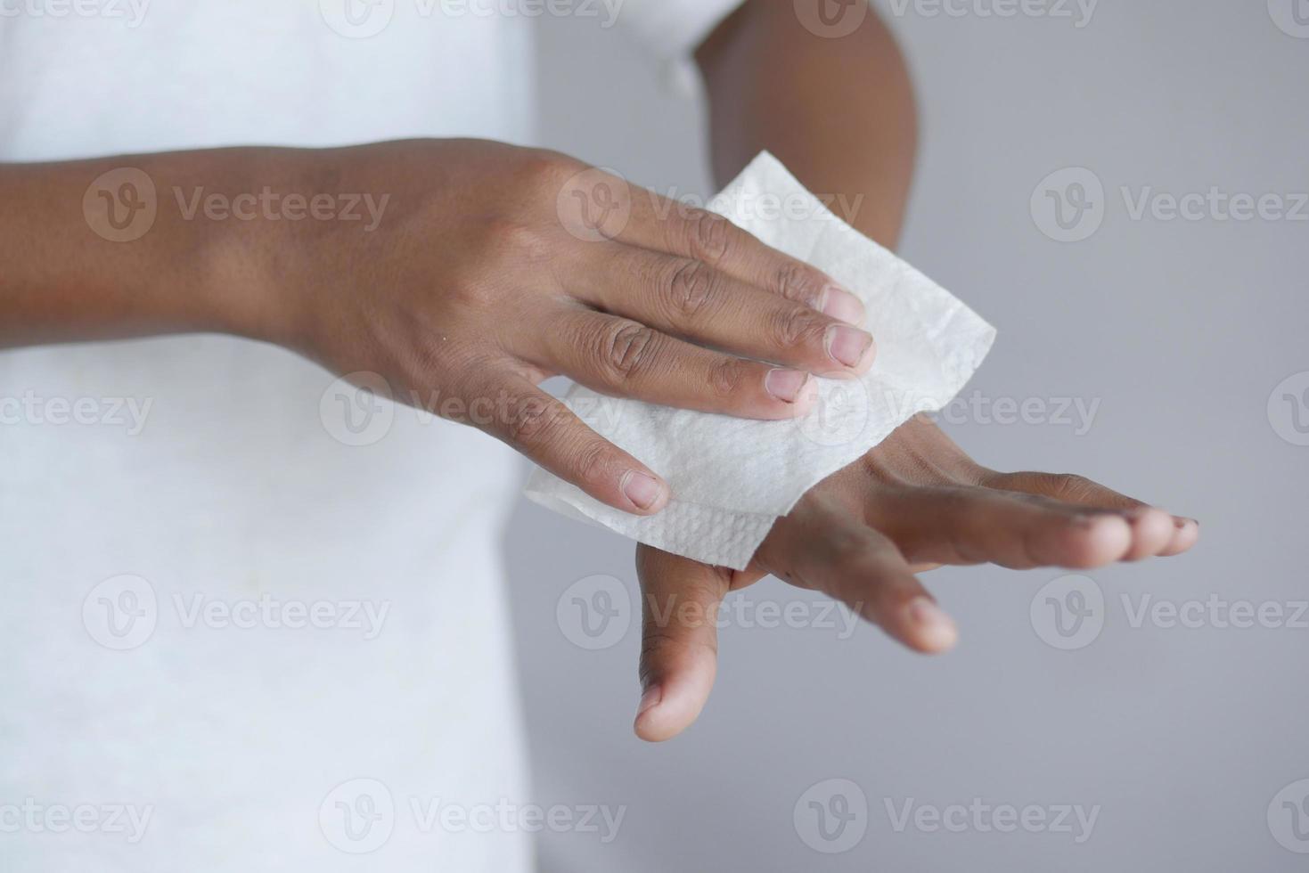man disinfecting his hands with a wet wipe. photo
