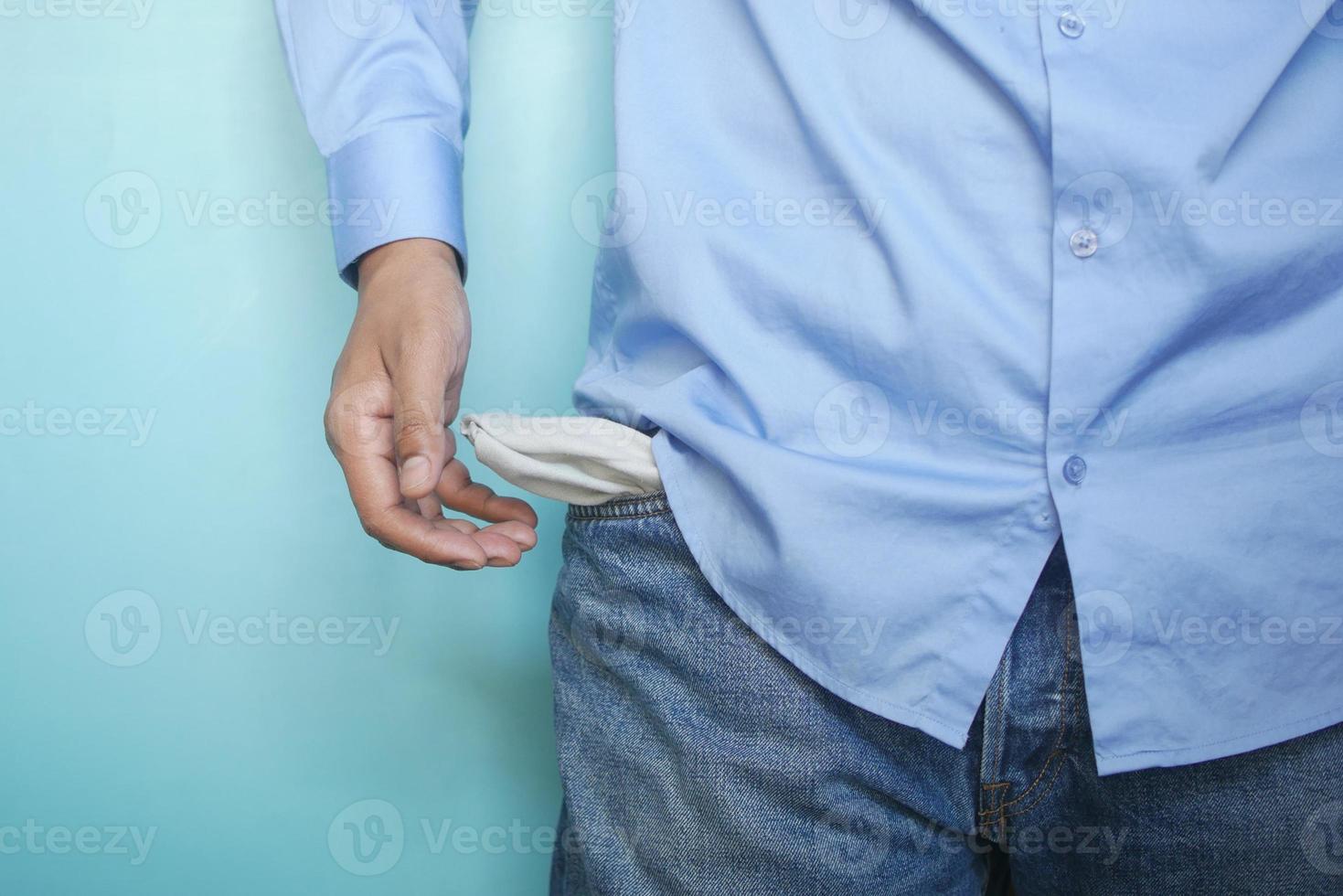 young man shows empty pant pocket with copy space photo