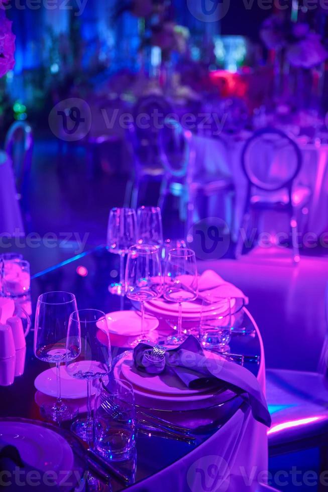 Table setup in purple light. Ready to event. Shallow dof photo