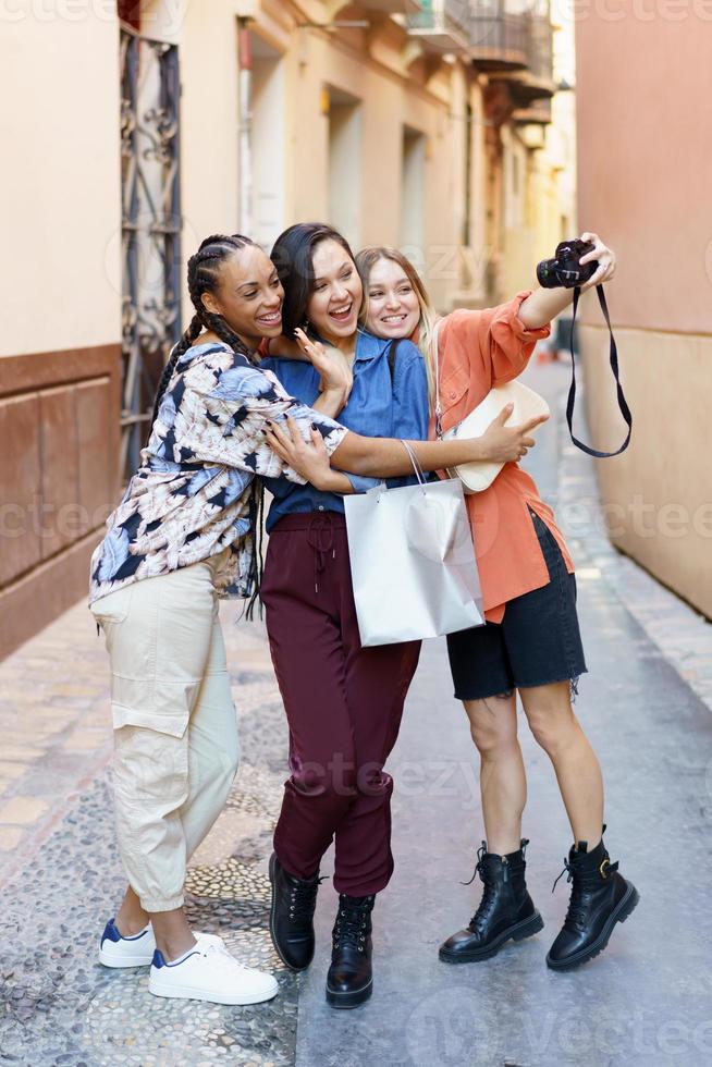 Cheerful diverse ladies taking selfie portrait in town photo