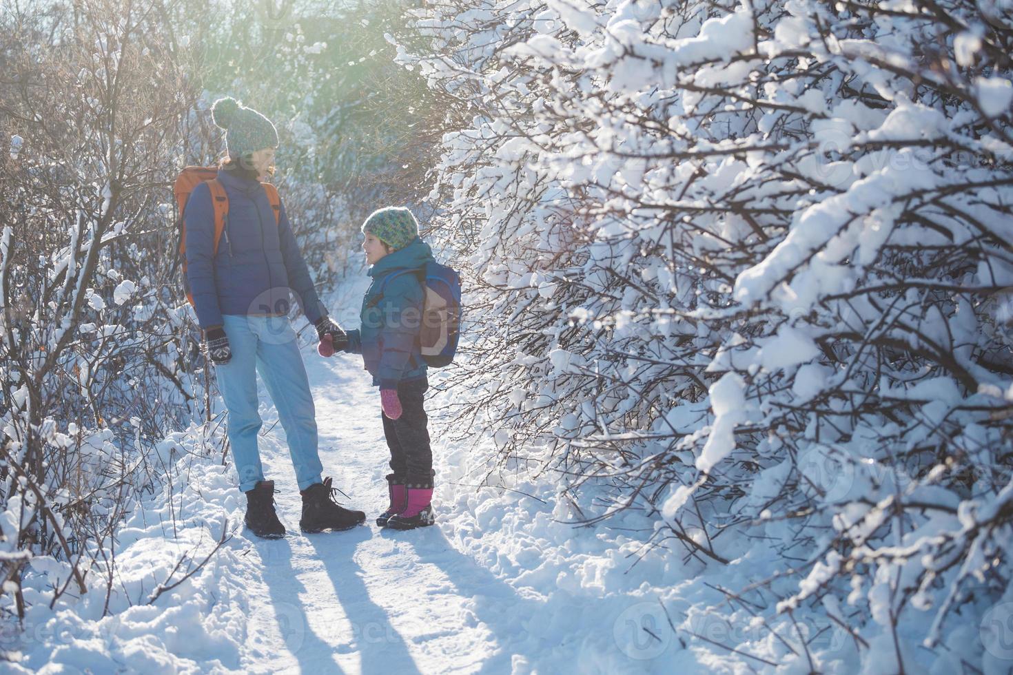 Woman with a child on a winter hike in the mountains. photo