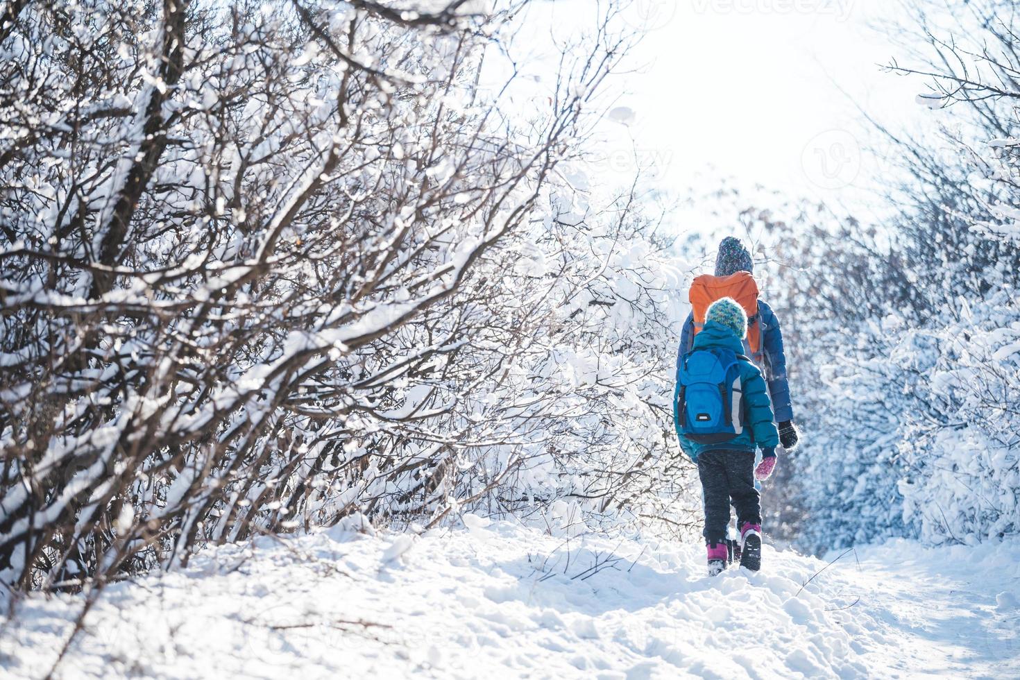 mujer con un niño en una caminata de invierno en las montañas. foto