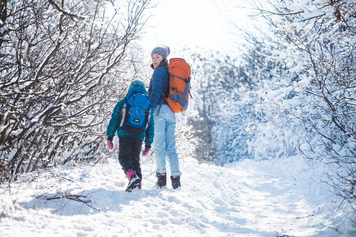 Woman with a child on a winter hike in the mountains. photo