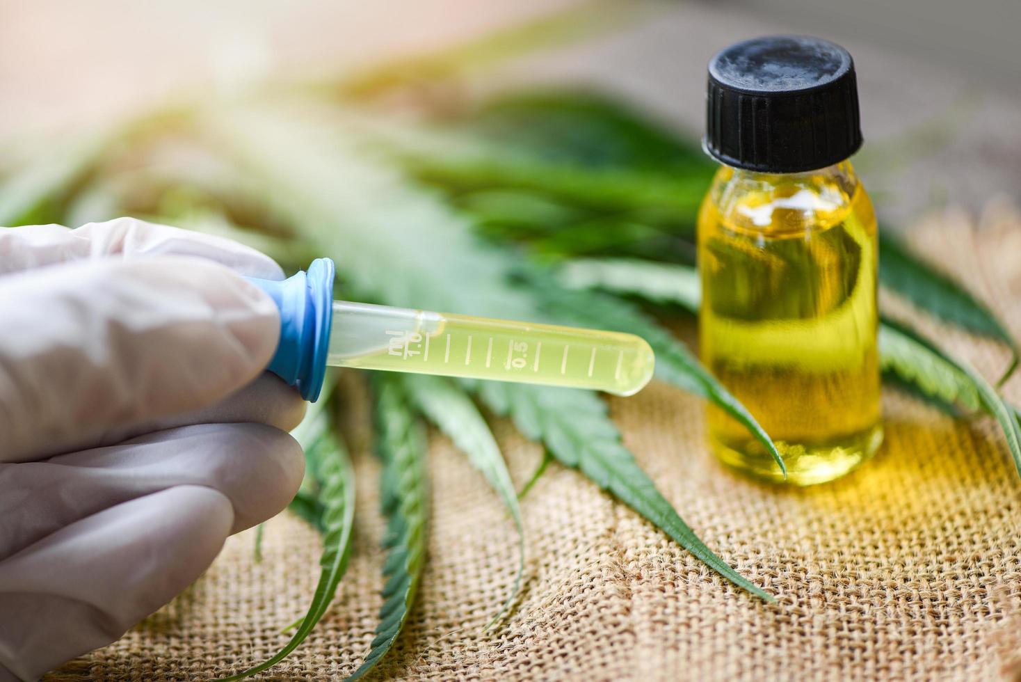 Cannabis oil in bottle products on sack background - THC and CBD oil extract from cannabis leaf marijuana photo