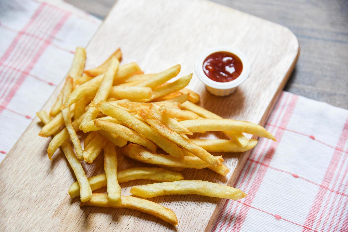 French fries on wooden board with ketchup photo